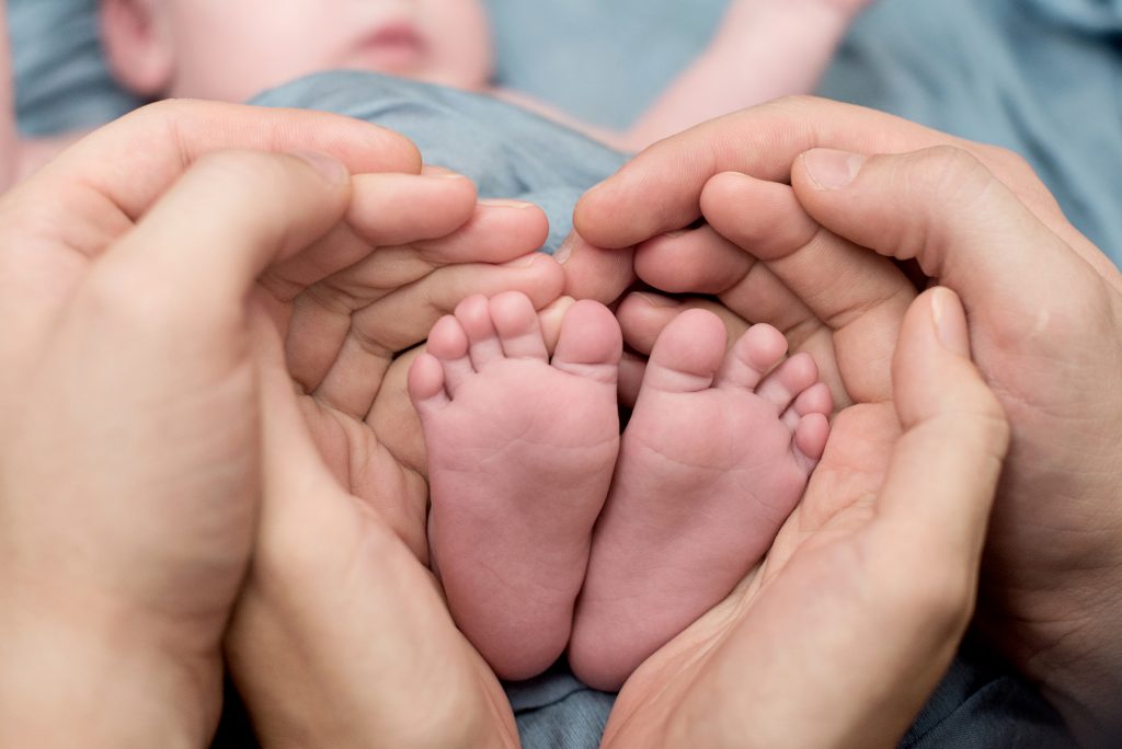 Doula Momma: Mother and father holding their newborn's little feet.